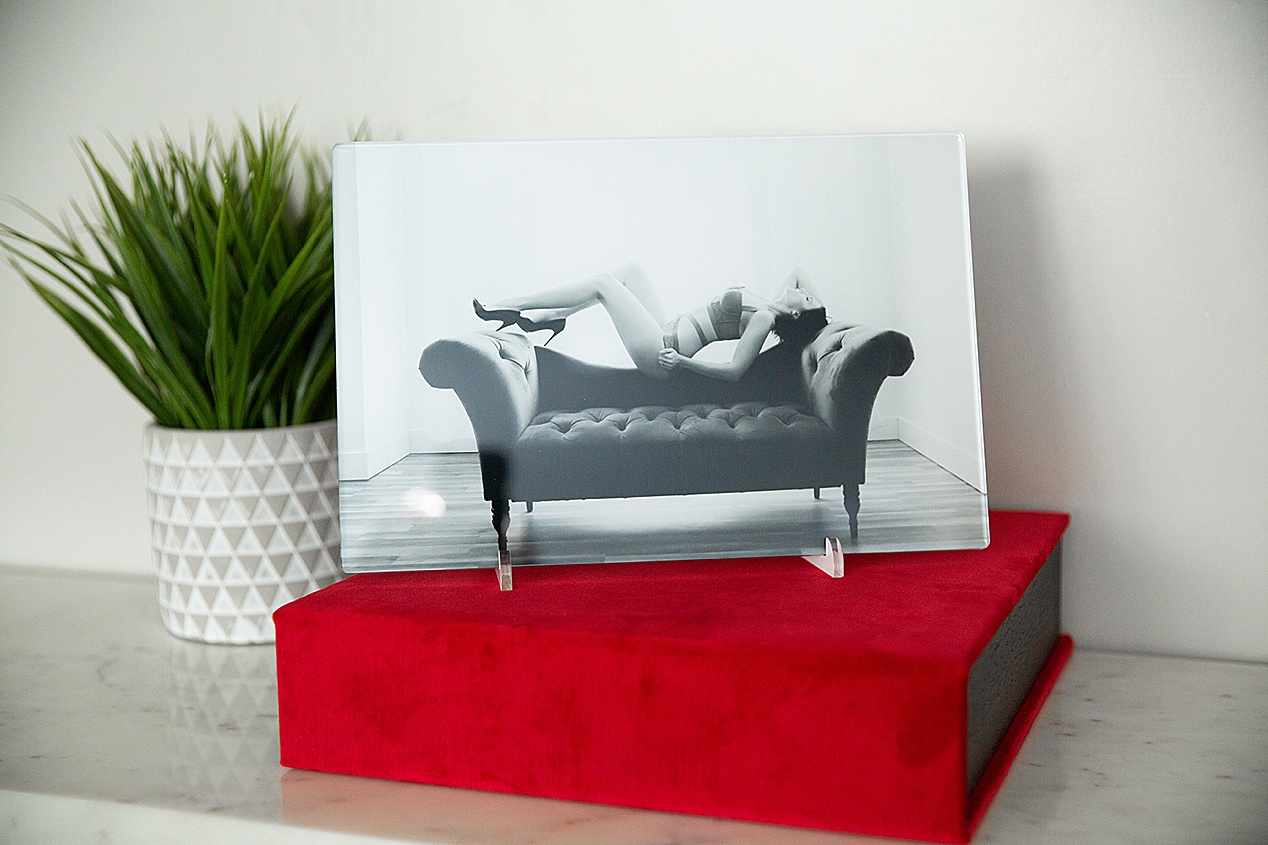 A red velvet box is the base for an 8x12 acrylic black and white print of a woman lying on the back of a sofa.