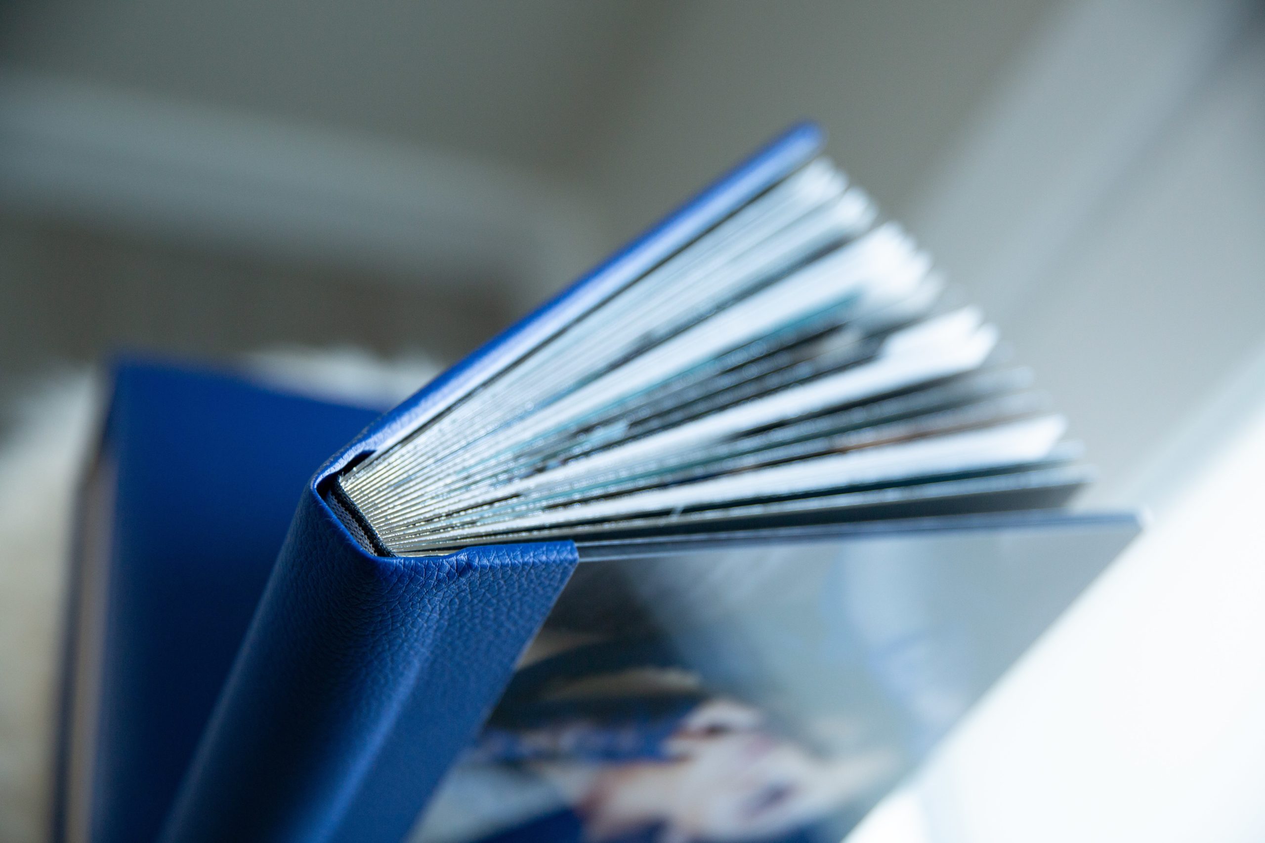 A Marine Blue Boudoir Album is displayed showcasing the quality of the square spine.