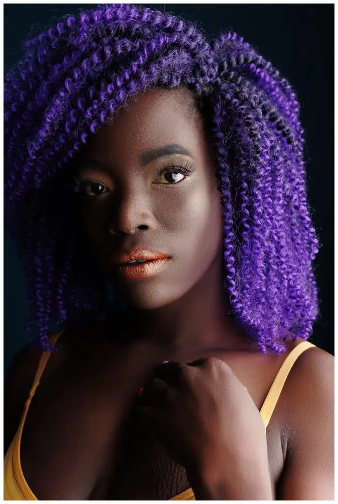 African American Woman with Purple hair in a yellow bodysuit in Boise Idaho's Boudoir Studio, Boudoir Defined.